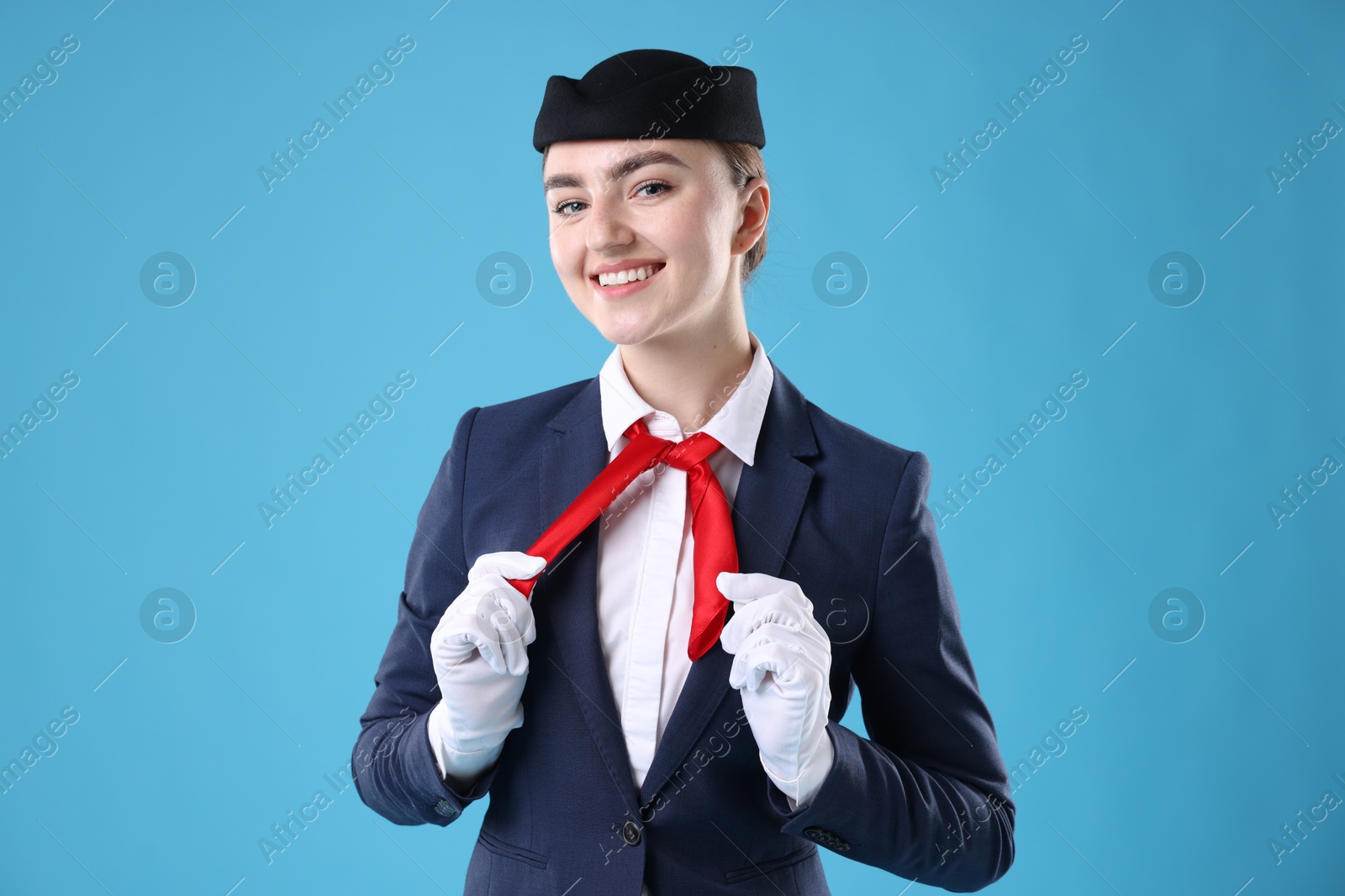 Photo of Charming stewardess in uniform on light blue background