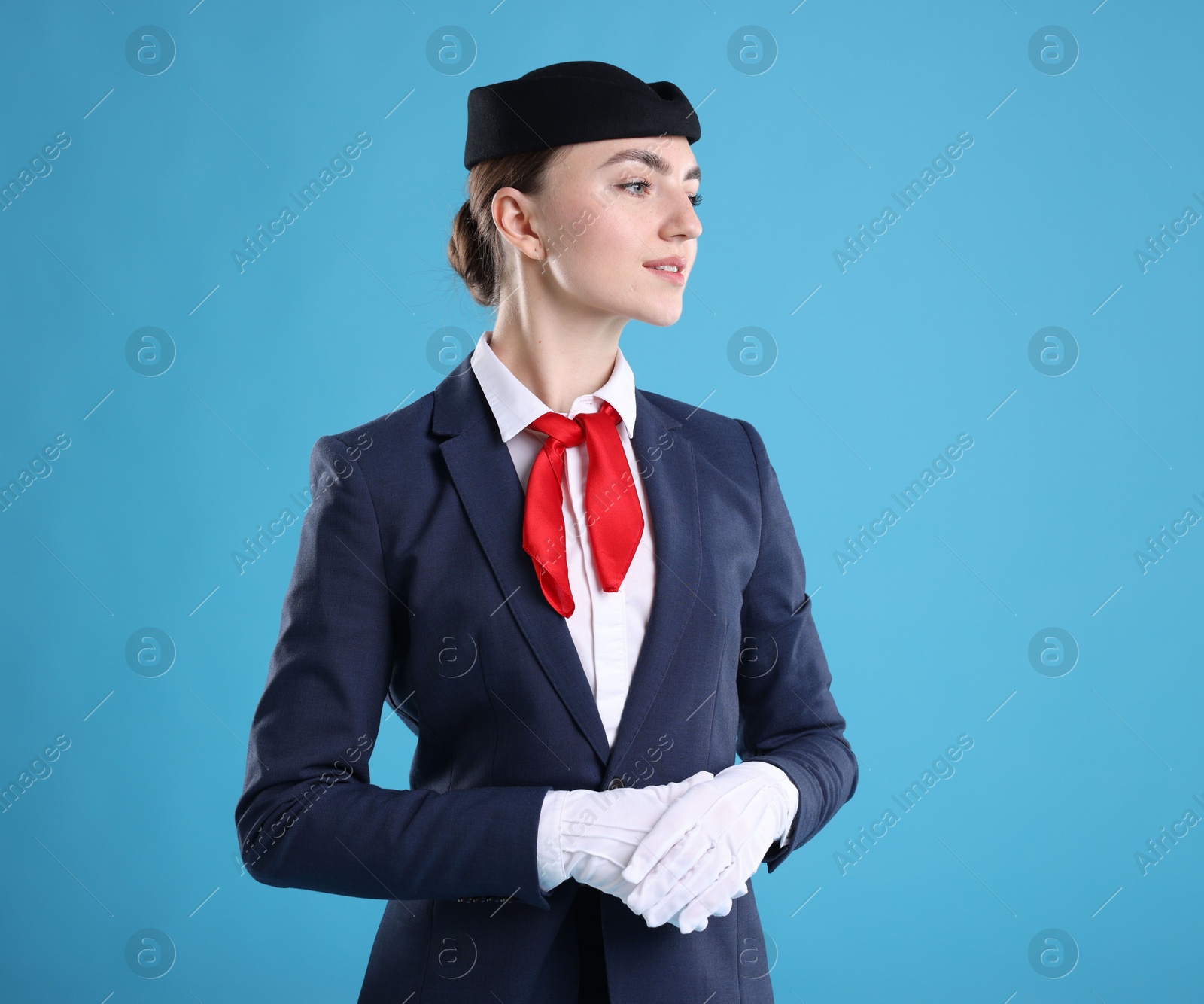 Photo of Charming stewardess in uniform on light blue background