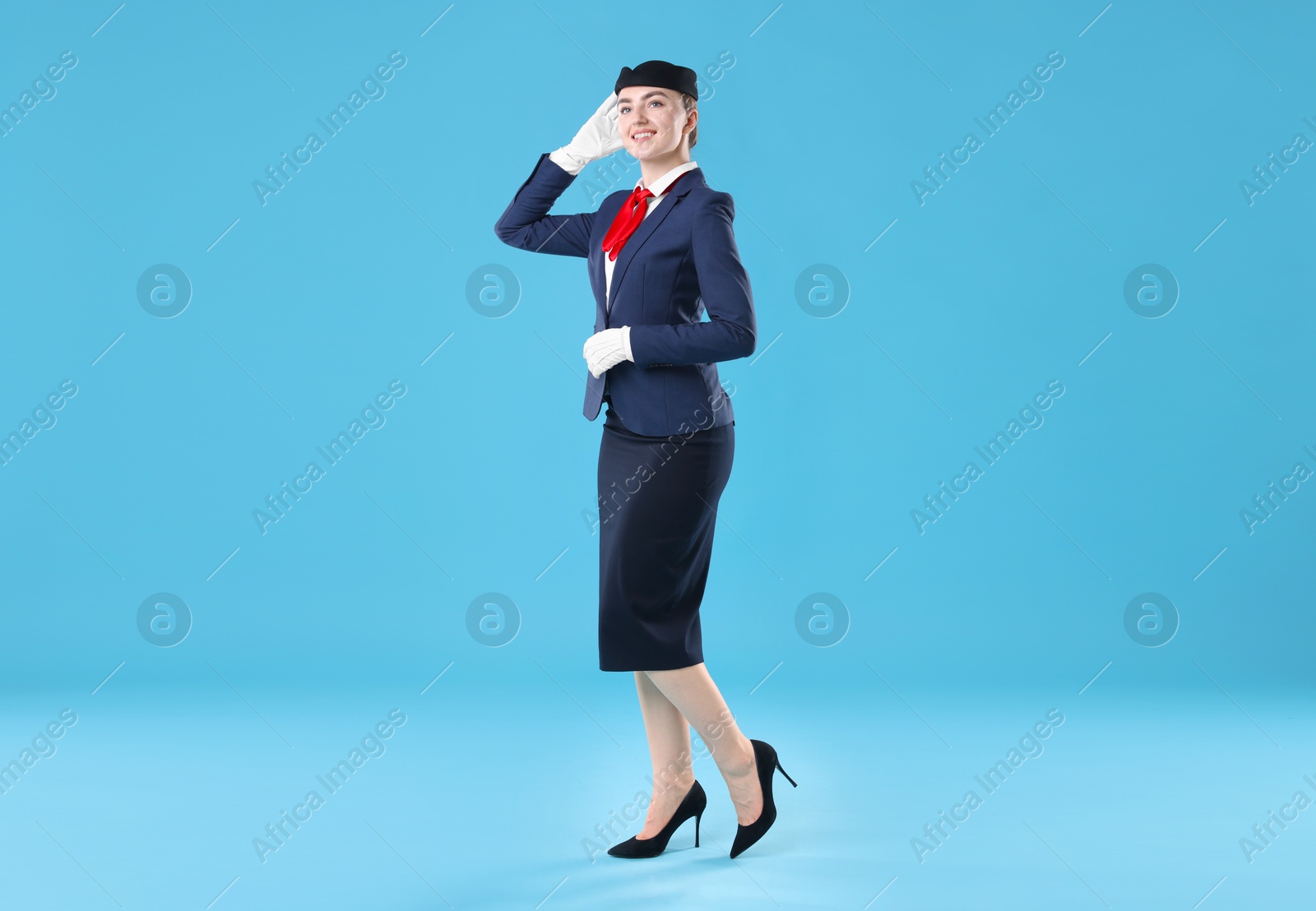 Photo of Charming stewardess in uniform on light blue background