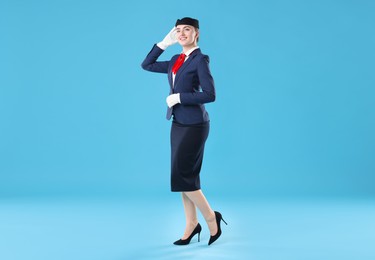 Photo of Charming stewardess in uniform on light blue background