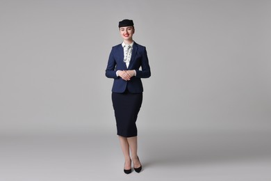 Photo of Charming stewardess in uniform on light grey background