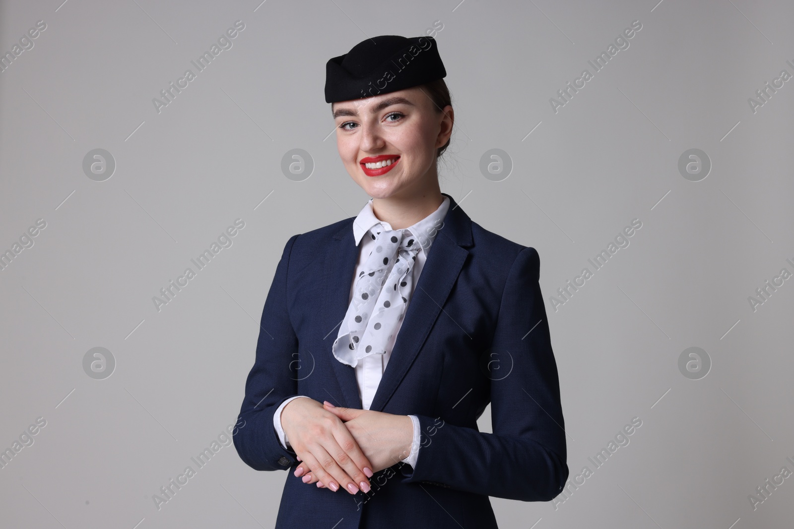 Photo of Charming stewardess in uniform on light grey background