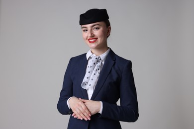 Photo of Charming stewardess in uniform on light grey background