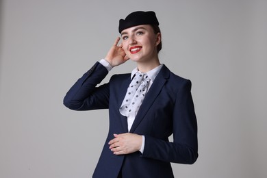 Photo of Charming stewardess in uniform on light grey background