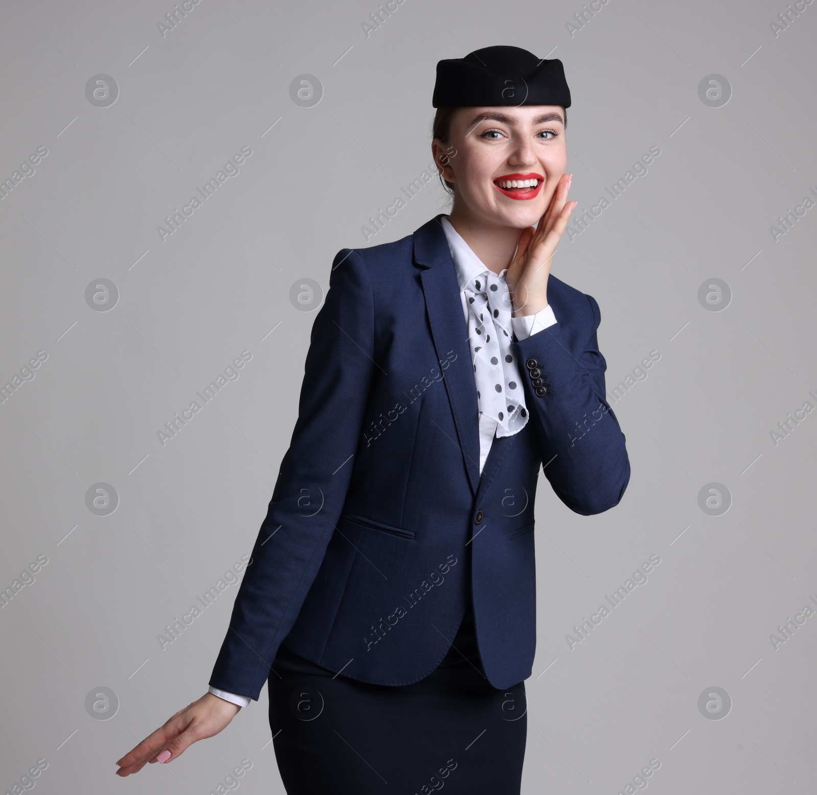 Photo of Charming stewardess in uniform on light grey background