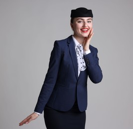 Photo of Charming stewardess in uniform on light grey background