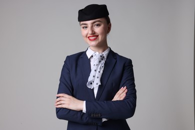 Photo of Charming stewardess in uniform on light grey background