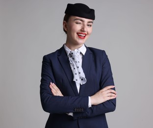 Photo of Charming stewardess in uniform on light grey background