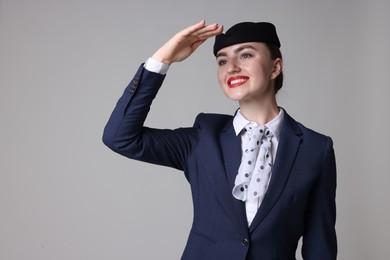 Photo of Charming stewardess in uniform on light grey background