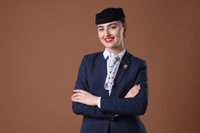 Photo of Charming stewardess in uniform on brown background