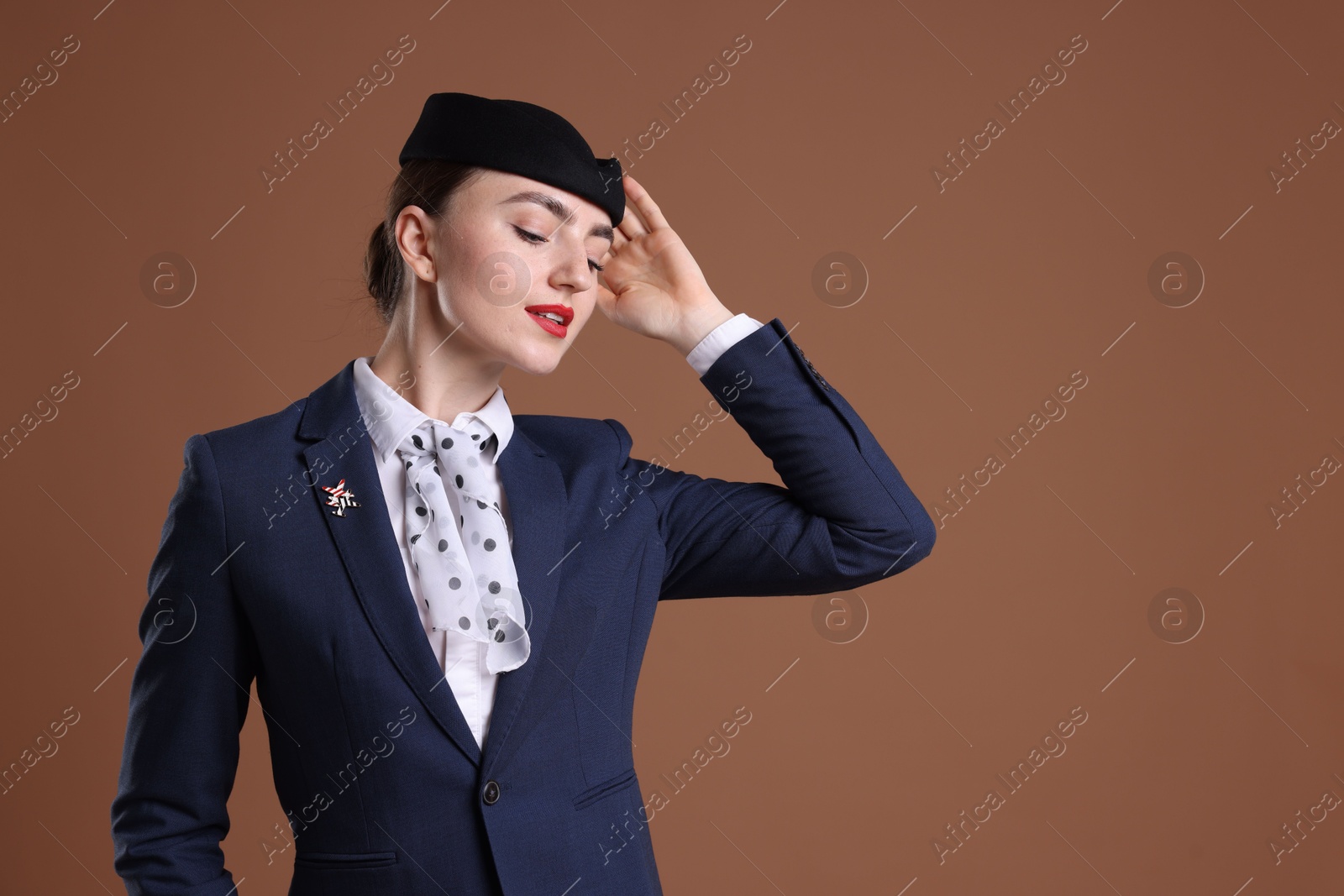 Photo of Charming stewardess in uniform on brown background. Space for text