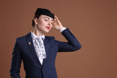 Photo of Charming stewardess in uniform on brown background. Space for text