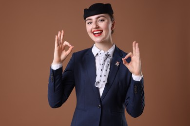 Photo of Charming stewardess showing okay gestures on brown background