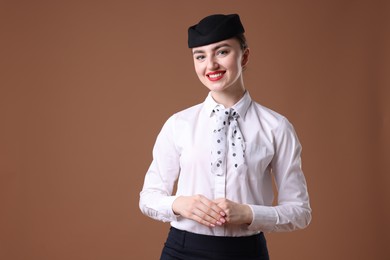 Photo of Charming stewardess in uniform on brown background. Space for text