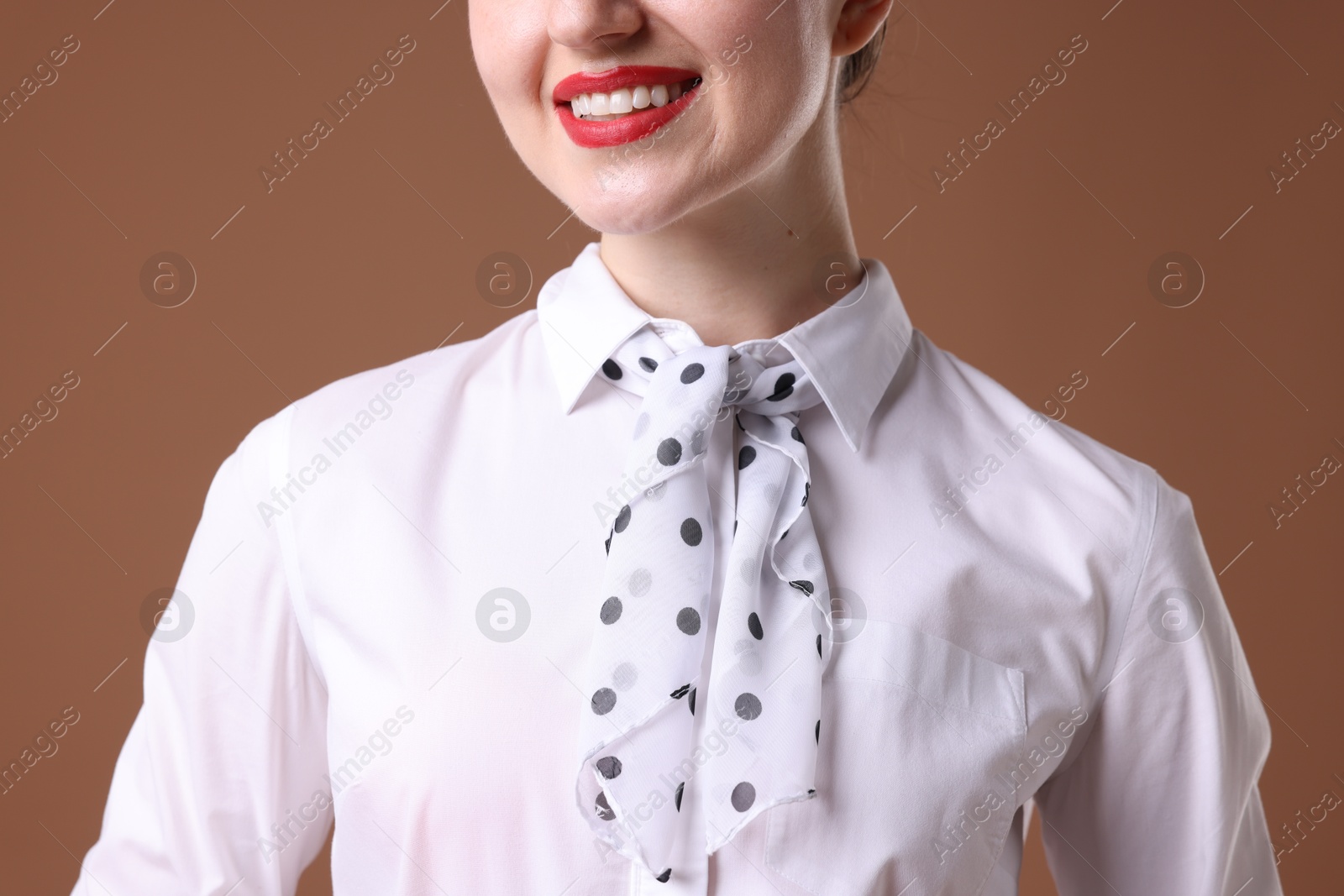 Photo of Charming stewardess in uniform on brown background, closeup