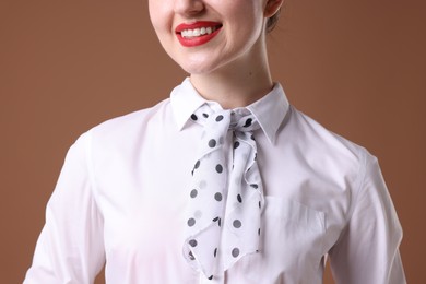 Photo of Charming stewardess in uniform on brown background, closeup