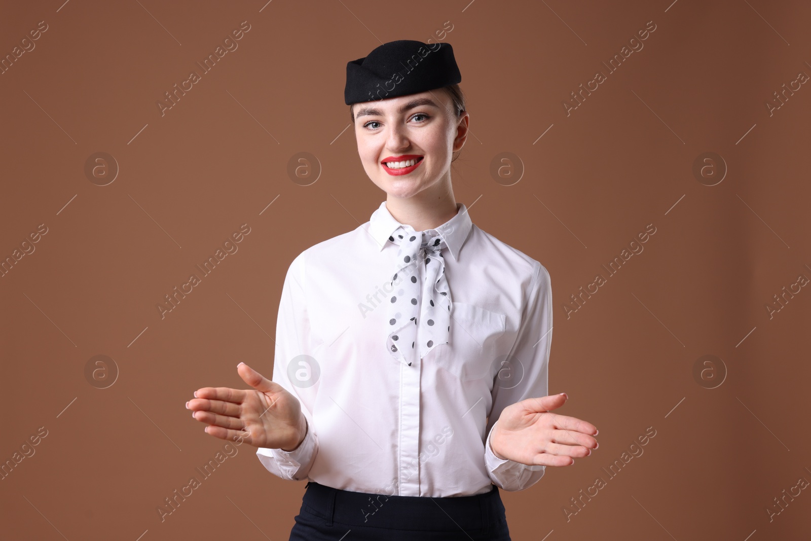 Photo of Positive stewardess doing pre-flight safety briefing on brown background