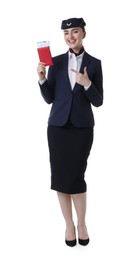Photo of Smiling stewardess pointing at passport and tickets on white background
