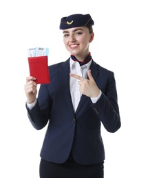 Photo of Smiling stewardess pointing at passport and tickets on white background