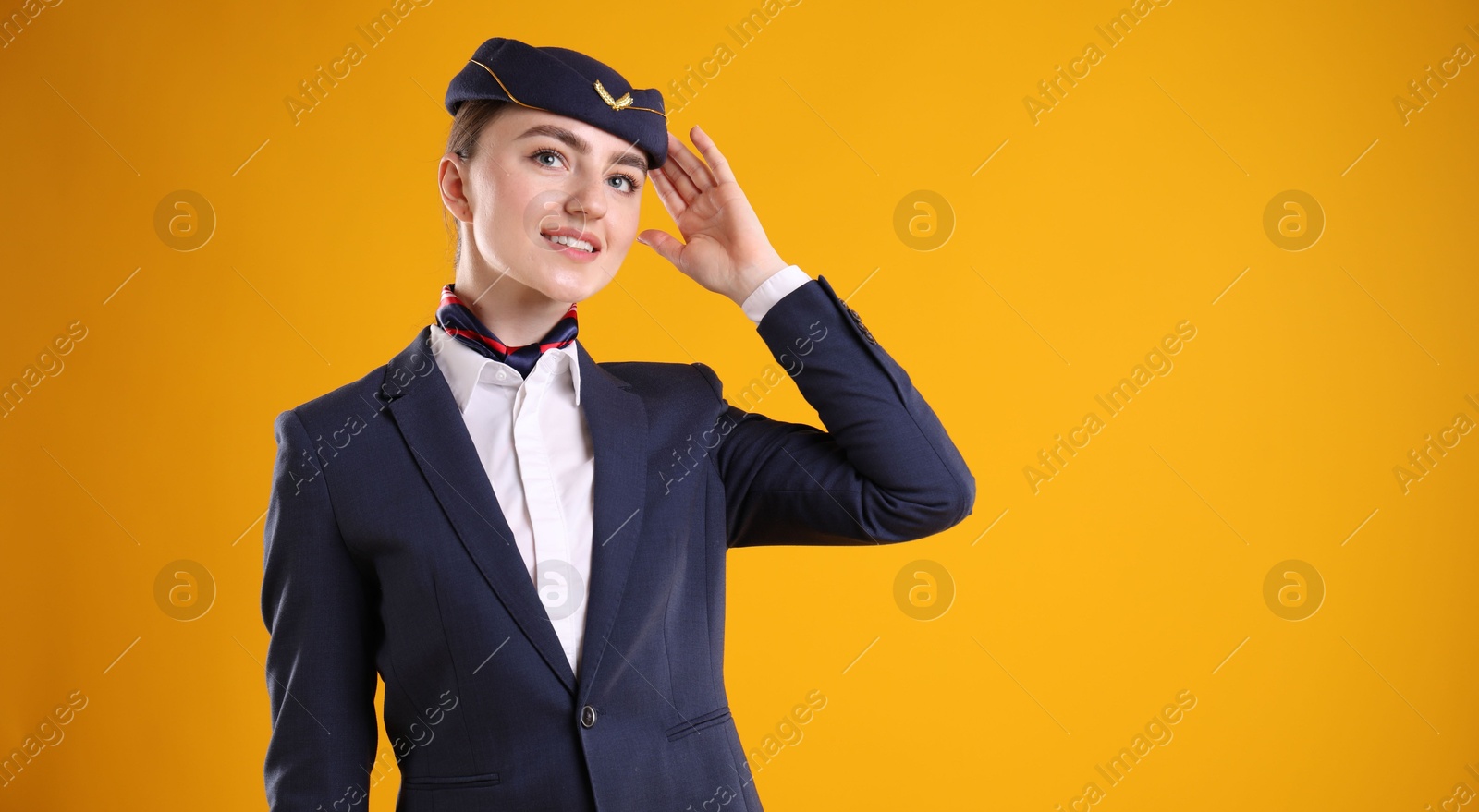 Photo of Charming stewardess in uniform on yellow background. Space for text