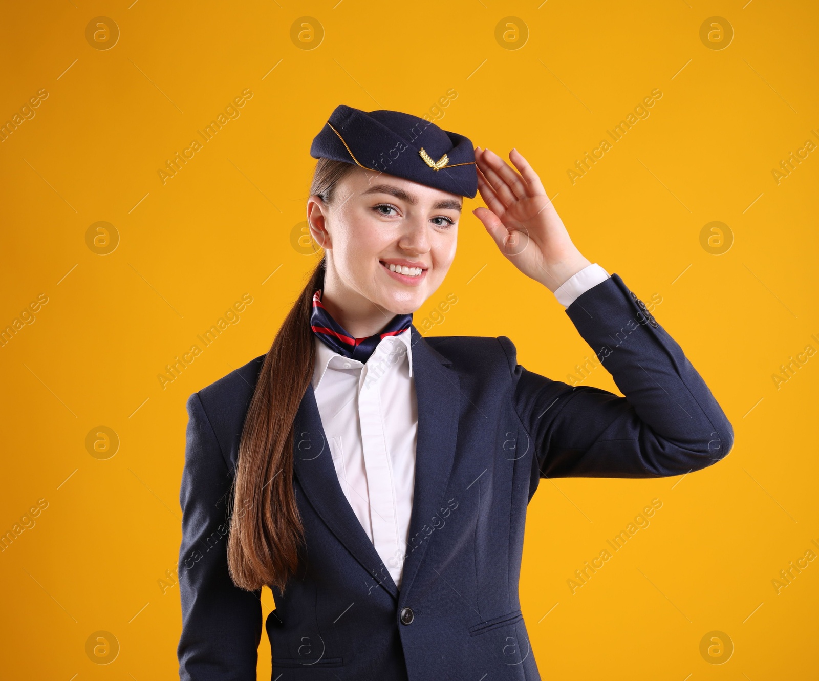 Photo of Charming stewardess in uniform on yellow background