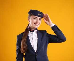 Photo of Charming stewardess in uniform on yellow background