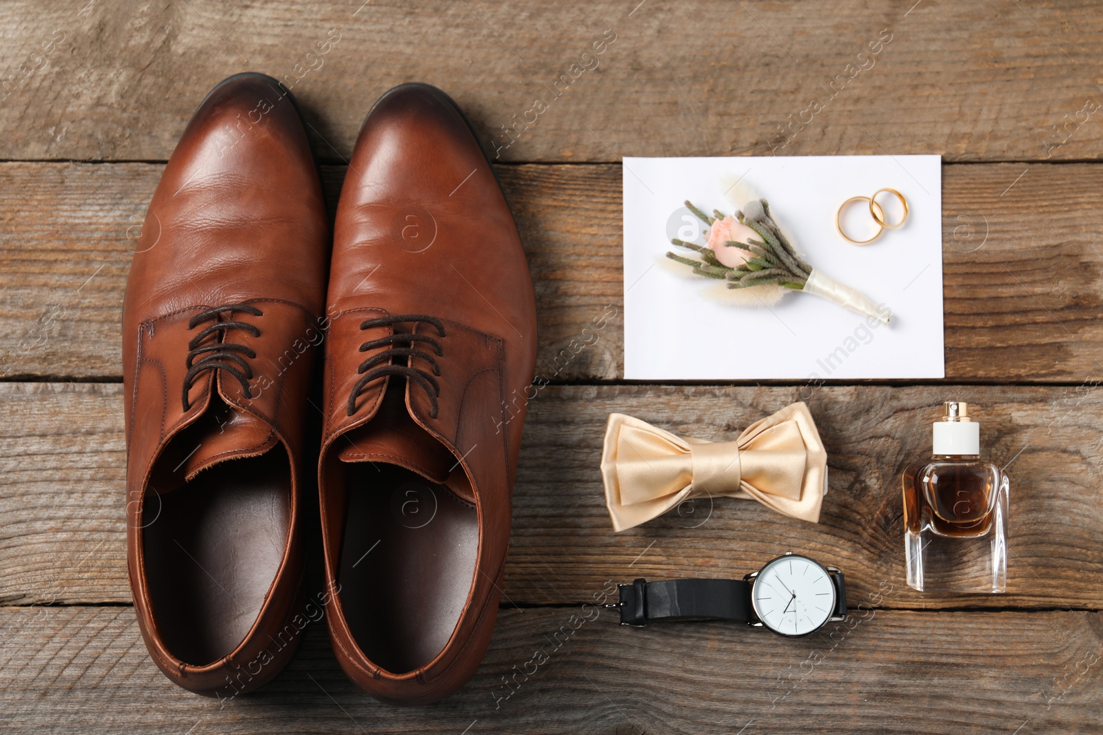 Photo of Flat lay composition with boutonniere and groom's accessories on wooden background