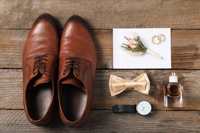 Photo of Flat lay composition with boutonniere and groom's accessories on wooden background