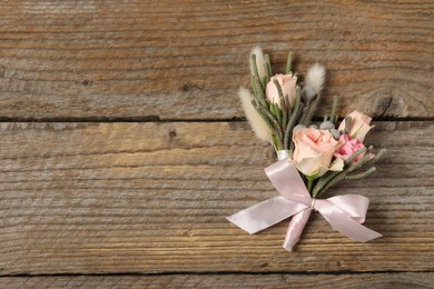Photo of Boutonnieres with beautiful flowers on wooden background, flat lay. Space for text