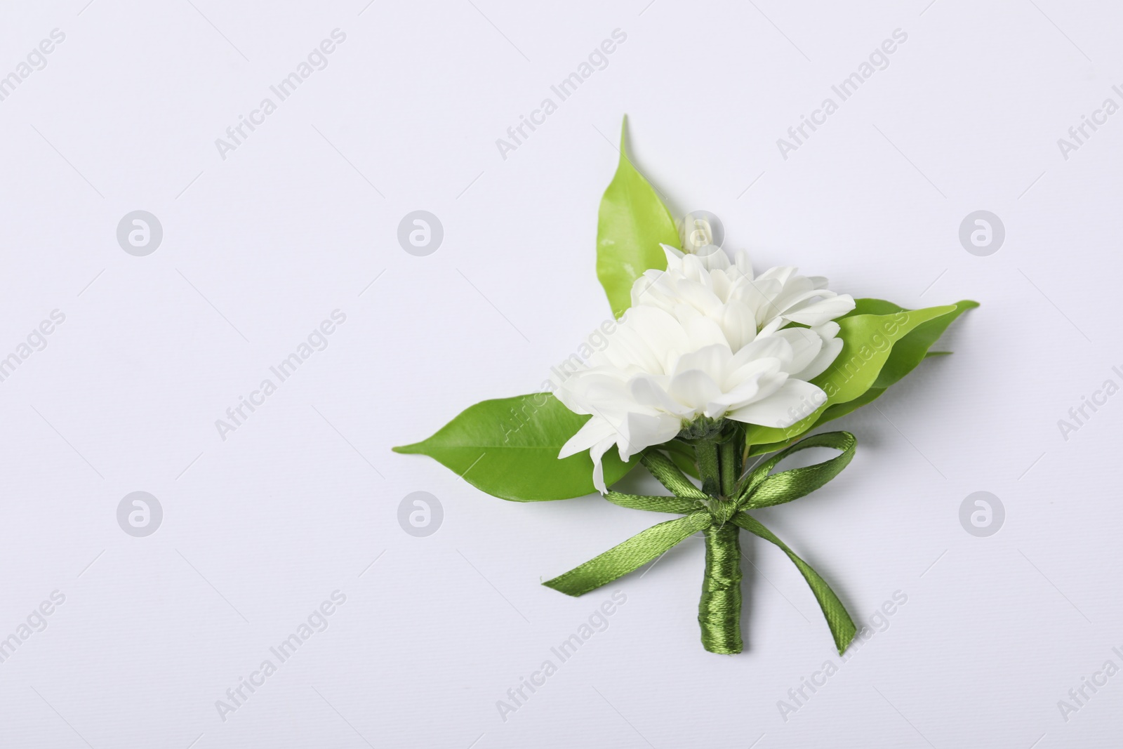 Photo of Boutonniere with beautiful flowers on white background, top view. Space for text