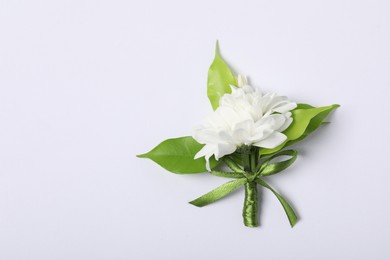 Photo of Boutonniere with beautiful flowers on white background, top view. Space for text
