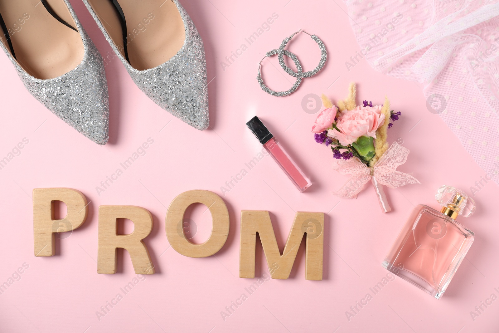 Photo of Flat lay composition with word Prom made of wooden letters, boutonniere and accessories on light pink background