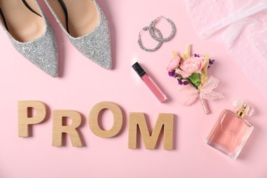 Photo of Flat lay composition with word Prom made of wooden letters, boutonniere and accessories on light pink background