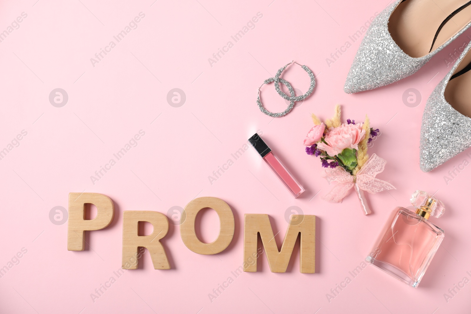 Photo of Flat lay composition with word Prom made of wooden letters, boutonniere and accessories on light pink background