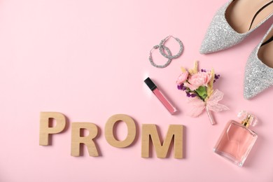 Photo of Flat lay composition with word Prom made of wooden letters, boutonniere and accessories on light pink background