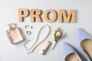 Photo of Flat lay composition with word Prom made of wooden letters, boutonniere and accessories on white background