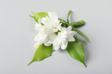 Photo of Boutonniere with beautiful flowers on light background, closeup