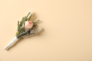 Photo of Boutonniere with beautiful flowers on beige background, top view. Space for text