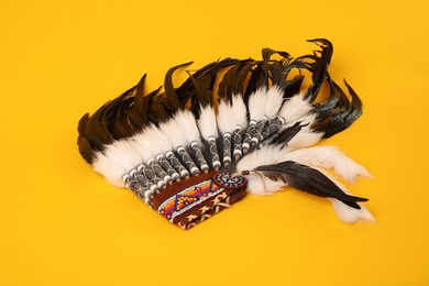 Photo of Traditional warbonnet (Native American chief headdress) on yellow background