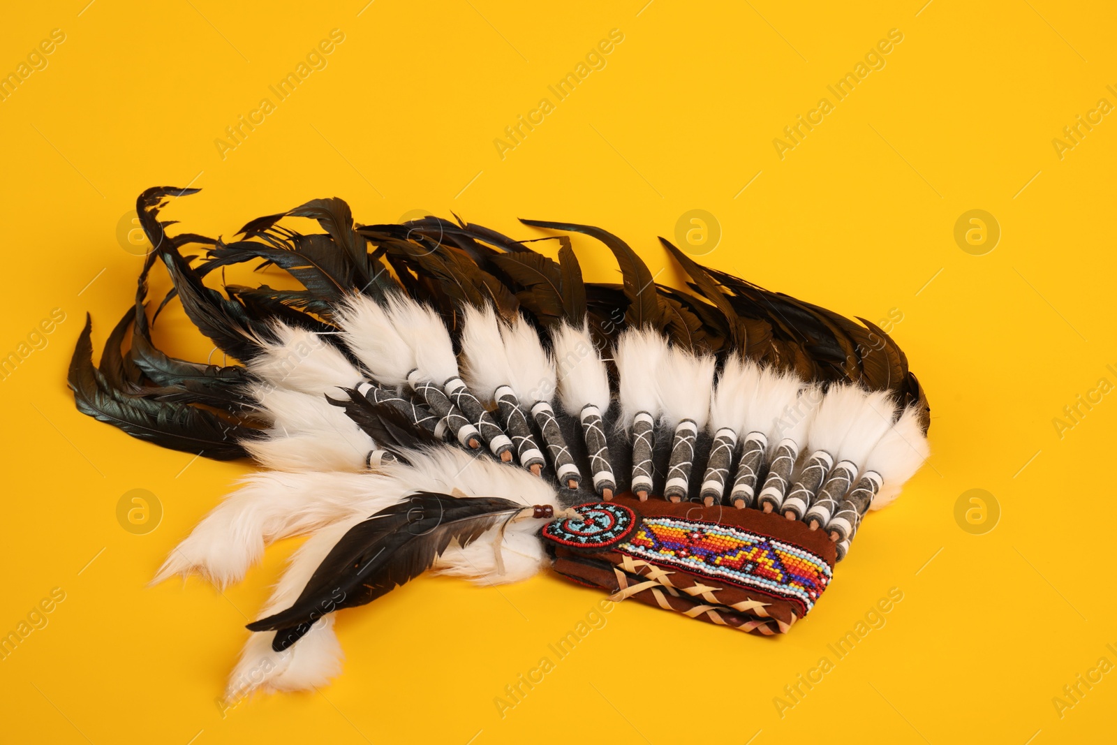 Photo of Traditional warbonnet (Native American chief headdress) on yellow background