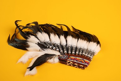 Photo of Traditional warbonnet (Native American chief headdress) on yellow background