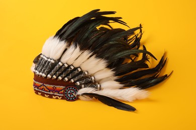 Photo of Traditional warbonnet (Native American chief headdress) on yellow background