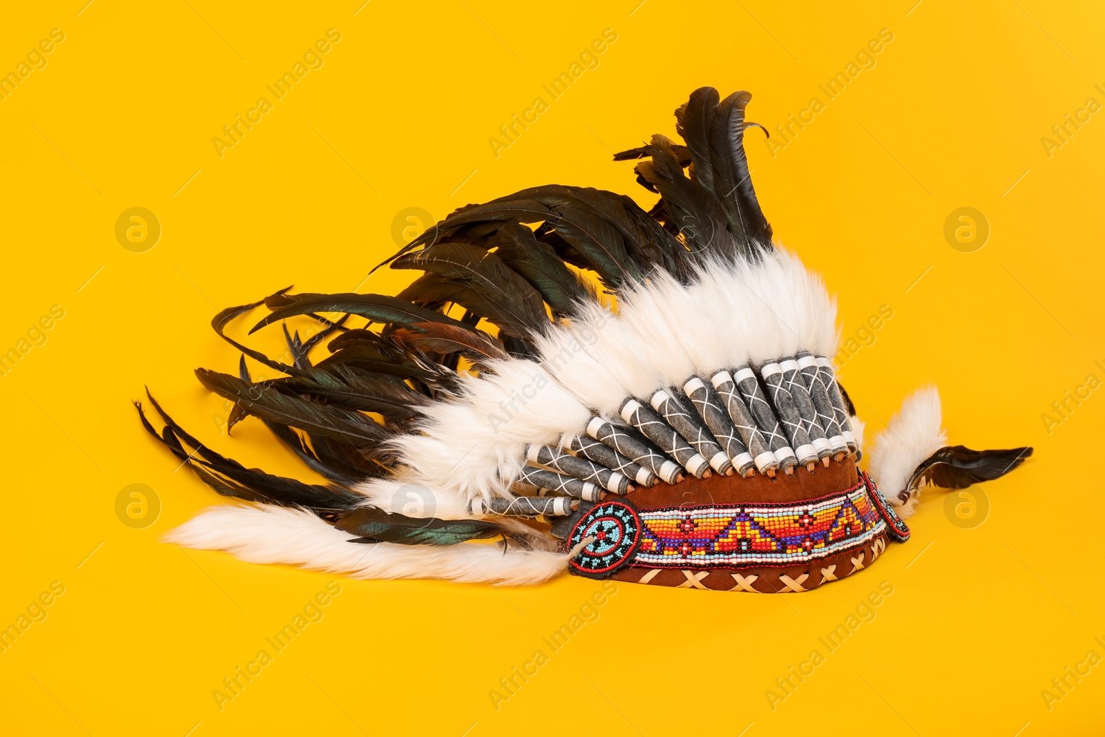 Photo of Traditional warbonnet (Native American chief headdress) on yellow background