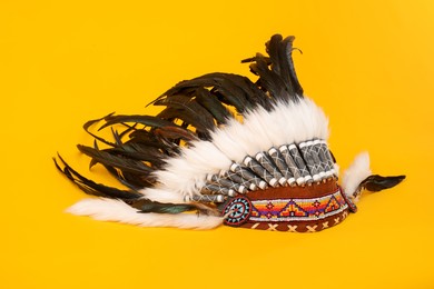 Photo of Traditional warbonnet (Native American chief headdress) on yellow background