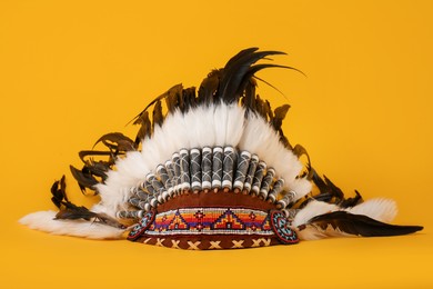 Photo of Traditional warbonnet (Native American chief headdress) on yellow background