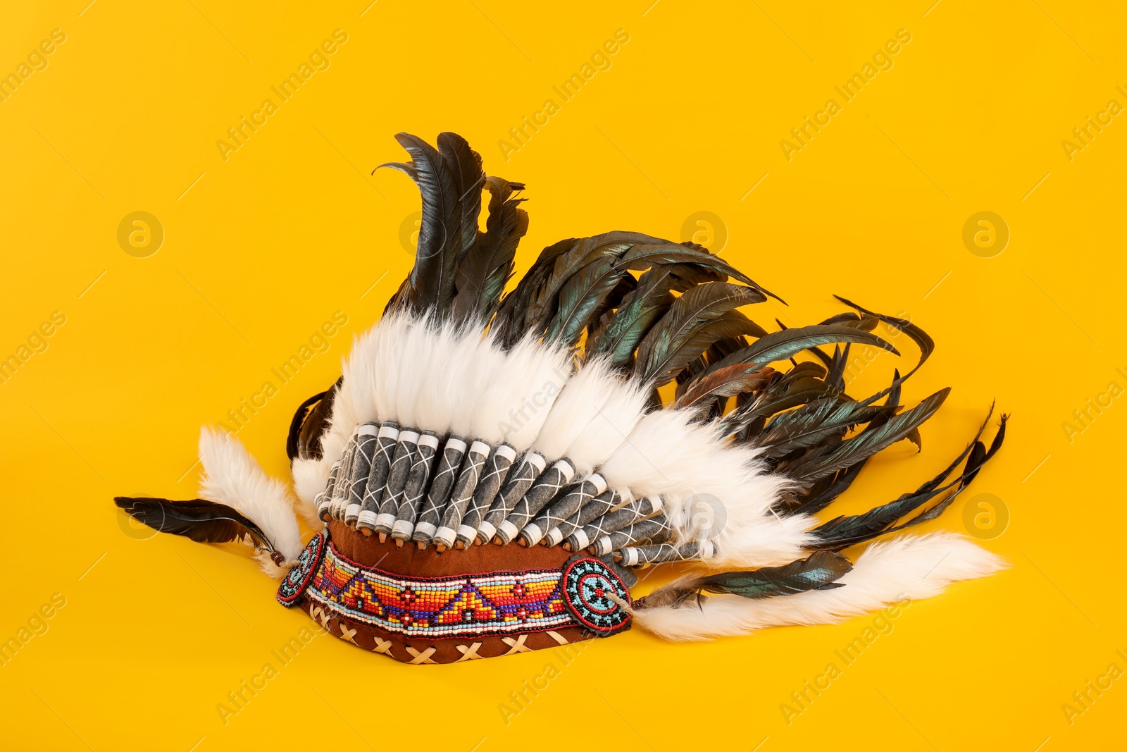 Photo of Traditional warbonnet (Native American chief headdress) on yellow background