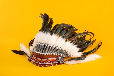 Photo of Traditional warbonnet (Native American chief headdress) on yellow background