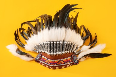 Photo of Traditional warbonnet (Native American chief headdress) on yellow background