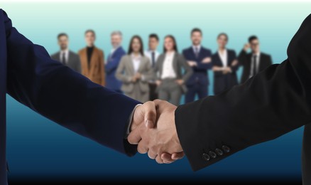 Image of Partners shaking hands against blurred group of business people