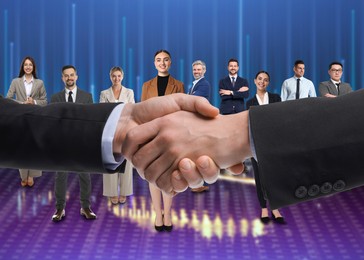 Image of Partners shaking hands against group of business people